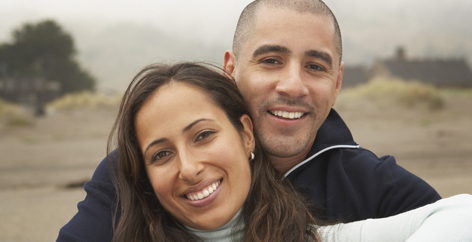 56970802 Portrait of couple sitting together at beach