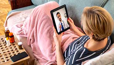 a woman using a tablet to speak to a doctor