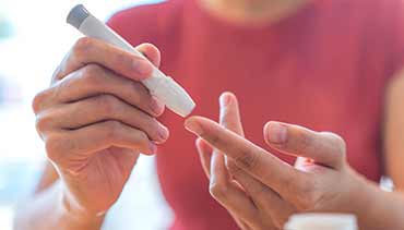 a woman pricking her finger with a monitor